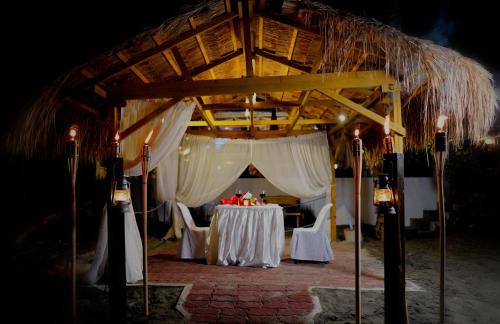 a table with white table cloths on it in a pavilion at P&M Final Option Beach Resort in San Juan