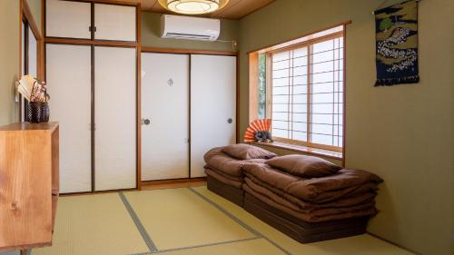 a living room with a brown couch and a window at Geisha House Atami - fireworks view in Atami