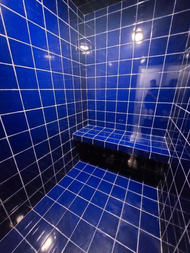 a blue tiled bathroom with a blue tile floor at Elixia Emerald 2 Bed Room Fully Furnished Apartment, Colombo, Malabe in Malabe