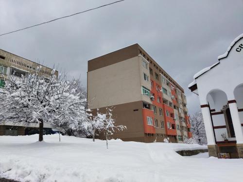 a building with snow in front of a building at Апартамент Панорама Трявна - кът за отдих, въздухолечение и почивка in Tryavna