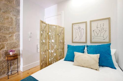- une chambre avec un lit blanc et des oreillers bleus dans l'établissement Oporto Cosy Apartment, à Porto