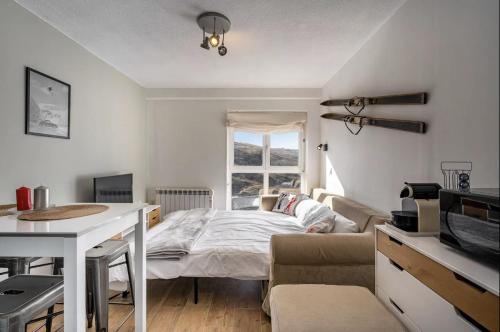 Un dormitorio con una cama y un sofá y una ventana. en Estudio Jimena Alcazaba, en Sierra Nevada