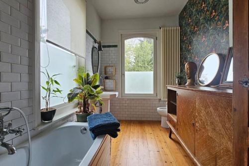 een badkamer met een bad, een toilet en een raam bij Maison de Caractère 8 pers - Jardin - in Lambersart