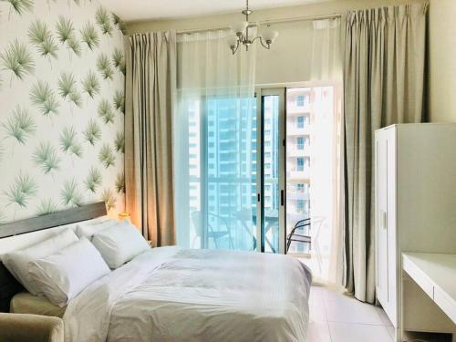 a bedroom with a bed and a large window at Full sea view with balcony with 5 stars hotel exceptional entertainment - Studio Apartment - 10 min to JBR - in Dubai