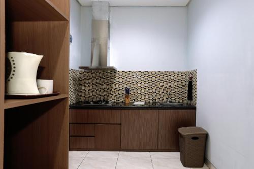 eine Küche mit einer Spüle und einer Theke in der Unterkunft ARCS House Pakubuwono by Jambuluwuk in Jakarta