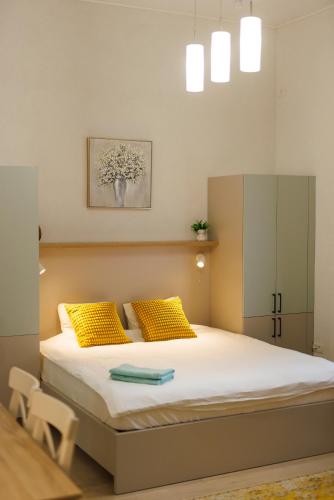 a bedroom with a large bed with yellow pillows at Victoriei Square Apartment in Timişoara