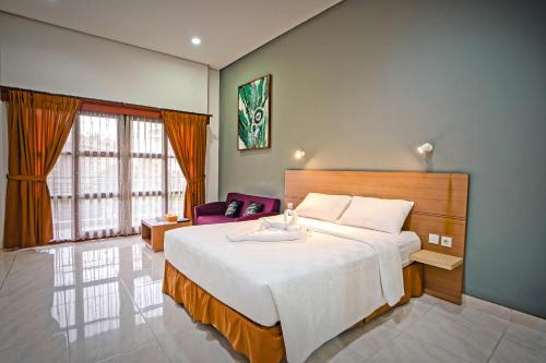 a bedroom with a large bed and a large window at ARCS House Pakubuwono by Jambuluwuk in Jakarta