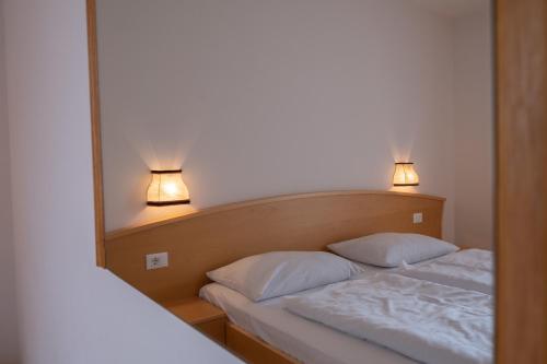 um quarto com uma cama com duas almofadas e um espelho em Fewo Zweiraum im Haus Götsch 5 em Parcines