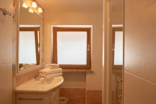 uma casa de banho com um lavatório, um WC e um espelho. em Fewo Zweiraum im Haus Götsch 5 em Parcines