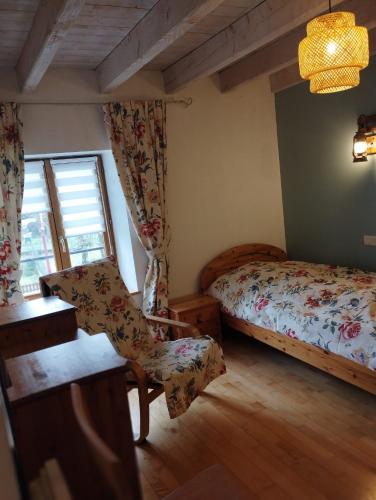 une chambre avec un lit, une chaise et une fenêtre dans l'établissement Le Stadl Vosges, à Jussarupt