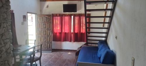 ein Wohnzimmer mit einer Treppe und einem roten Vorhang in der Unterkunft Casa en el faro sona sur asta 5 plazas in Mar del Plata