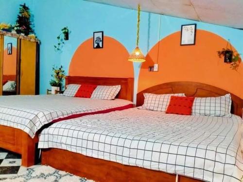 two beds in a bedroom with an orange at WINDY HILL VŨNG TÀU HOMESTAY in Vung Tau
