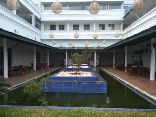 a large building with a fountain in a pool of water at Airport Hotel Dream Paradise in Ja-Ela