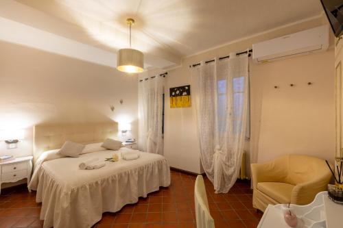 1 dormitorio con 1 cama blanca y 1 silla en Il Torrione, en Castiglione del Lago