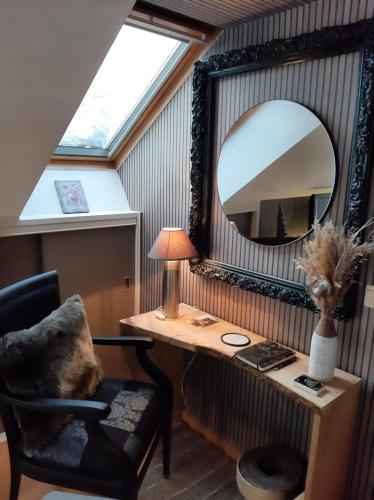 Pokój z biurkiem, lustrem i krzesłem w obiekcie Reve gourmand w mieście Beauraing
