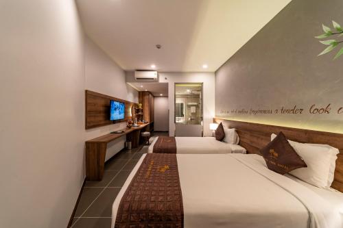 een hotelkamer met 2 bedden en een televisie bij Thanh Long Hotel - Bach Dang in Ho Chi Minh-stad