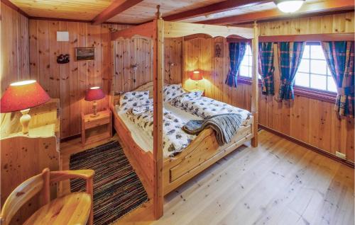 um quarto com uma cama num chalé de madeira em Amazing Home In stby With House A Mountain View em Østby