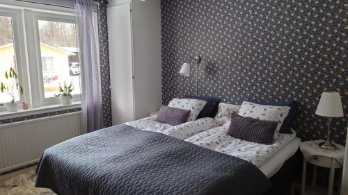 a bedroom with a bed with pillows and a window at Lilla Röaby in Bräkne-Hoby