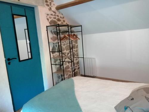 una habitación con una puerta azul y un estante de rocas en Gîte Le four à pain avec SPA, en Montmelard