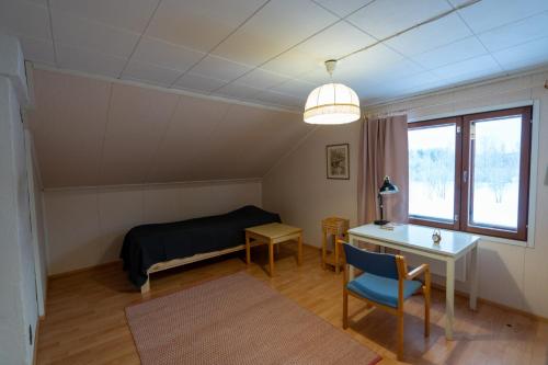 - une chambre avec un lit, un bureau et une fenêtre dans l'établissement Beekeepers House, à Ruovesi