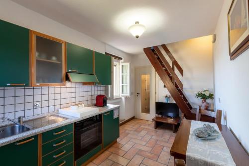 a kitchen with green cabinets and a sink at Il Torrione in Castiglione del Lago
