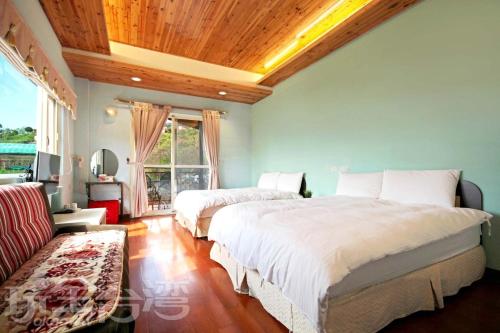 two beds in a bedroom with a wooden ceiling at Luxembourg in Ren'ai