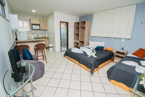 a living room with two beds and a kitchen at Residencial BoaVida in Fortaleza