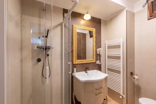 a bathroom with a shower and a sink and a mirror at Il Torrione in Castiglione del Lago
