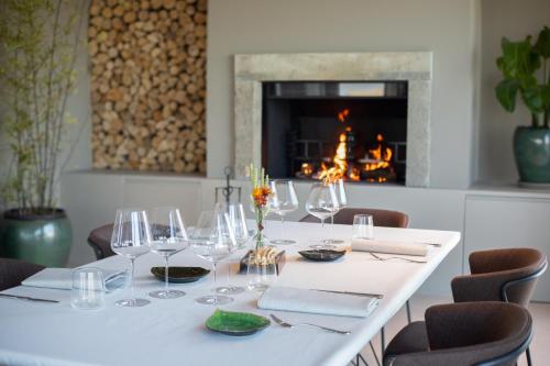 a white table with wine glasses and a fireplace at Coltivare AgriRelais in La Morra
