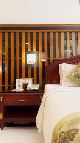 a bedroom with a bed and a wooden headboard at Hotel Mera Mann in Lucknow