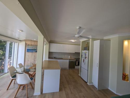 a kitchen with white appliances and a table and chairs at Phoenix Oasis, Family and Pet friendly, with private pool and spa in Port Macquarie