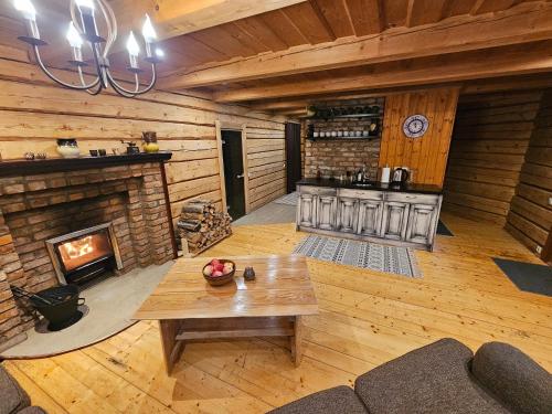 ein Wohnzimmer mit einem Kamin und einem Tisch in der Unterkunft Ziedu pirts in Auciems