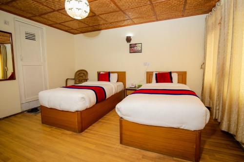 two beds sitting in a room with at The Muglan Hotel and Restaurant in Bhaktapur