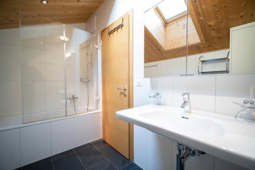 a bathroom with a sink and a shower at Chasa Bagnera 174 in Scuol