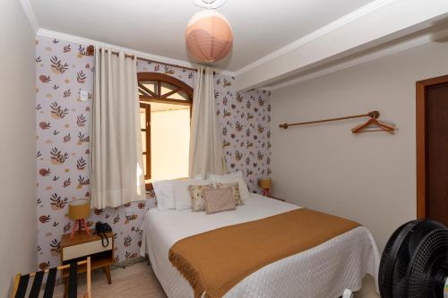 una camera da letto con un letto e una finestra di POUSADA CAPIM LIMÃO a Diamantina