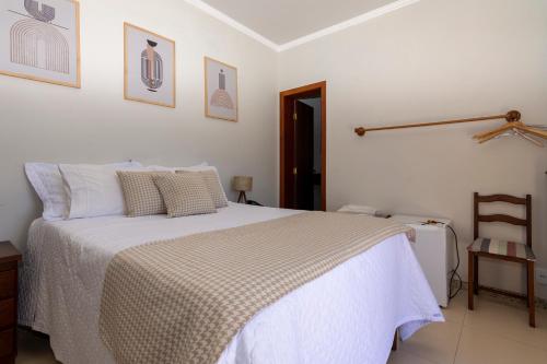 una camera da letto con un grande letto con lenzuola bianche di POUSADA CAPIM LIMÃO a Diamantina