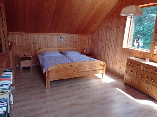 1 dormitorio con 1 cama en una habitación de madera en Chata Ujo, en Hranice