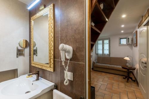a bathroom with a sink and a mirror and a tub at Il Torrione in Castiglione del Lago