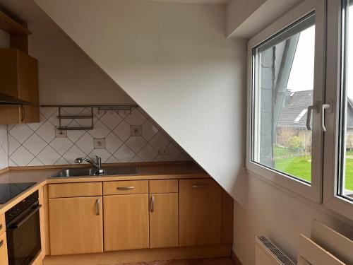 een keuken met een wastafel en een raam bij Ferienwohnung mit zwei Schlafzimmern in Kaarst bei Düsseldorf in Kaarst