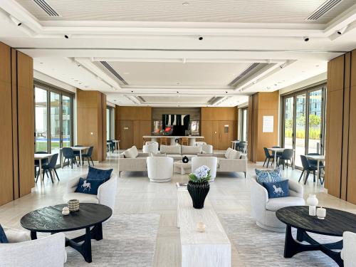 a lobby with tables and chairs and a living room at Amazing Burj Khalifa Views with Direct Dubai Mall Access, 2BR Apartment in Downtown Dubai in Dubai