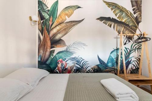 een slaapkamer met een muurschildering van planten aan de muur bij Le Jules de Toulouse in Toulouse