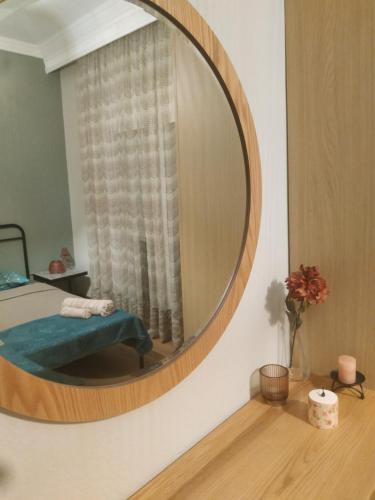 a round mirror on a wall with a chair in a room at Marvic House in Exaplátanos