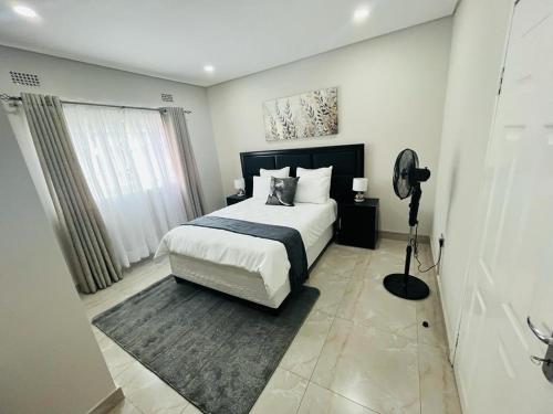 Un dormitorio con una cama con un edredón blanco y negro. en Elisheva apartment, en Ndola