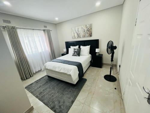 a bedroom with a bed with a black and white comforter at Elisheva apartment in Ndola