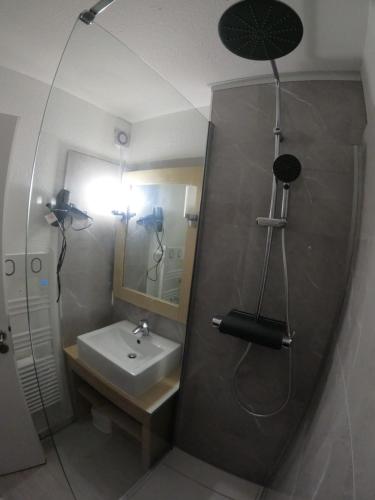 Un baño con ducha con lavabo y espejo. en Vue Golf dans Résidence Nature "SYMPALAPPART", en Moliets-et-Maa
