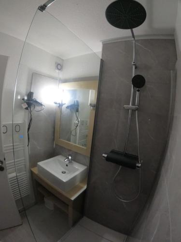 a bathroom with a shower with a sink and a mirror at Vue Golf dans Résidence Nature "SYMPALAPPART" in Moliets-et-Maa