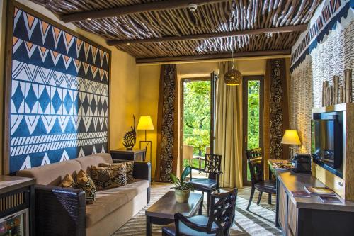 a living room with a couch and a tv at Bambara Hotel in Felsőtárkány