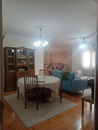 Luxury apartment in laurent في الإسكندرية: غرفة معيشة مع طاولة وأريكة زرقاء