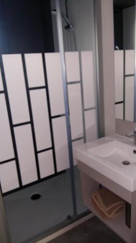 een badkamer met een witte wastafel en een douche bij Cottage chalet gîte l'Edune résidence de vacances location in Jullouville-les-Pins