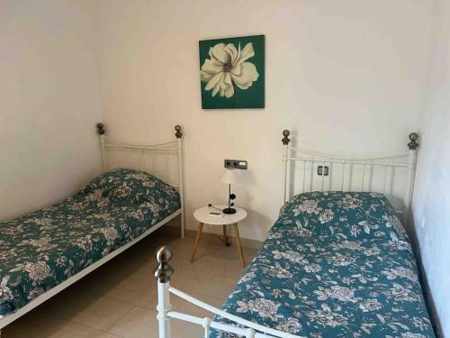 1 dormitorio con 2 camas y mesa con lámpara en La Manga Club - 21 El Rancho, en Cartagena
